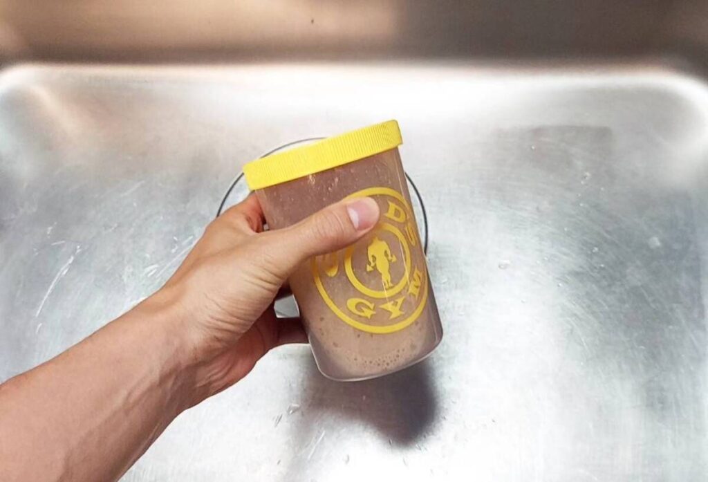 シンクの中でプロテインシェイカーを振る様子